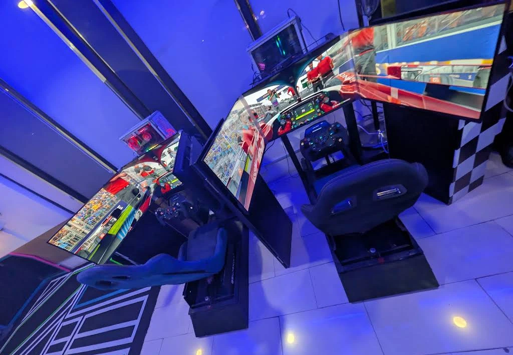 Two triple-screen racing simulator setups at Player One Victoria Island.