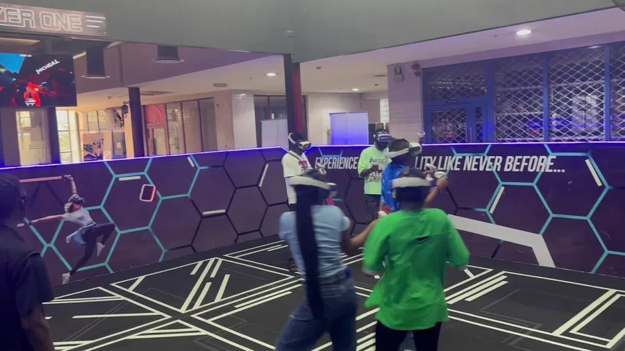Students and youth group playing VR arena games at Player One Game Cafe