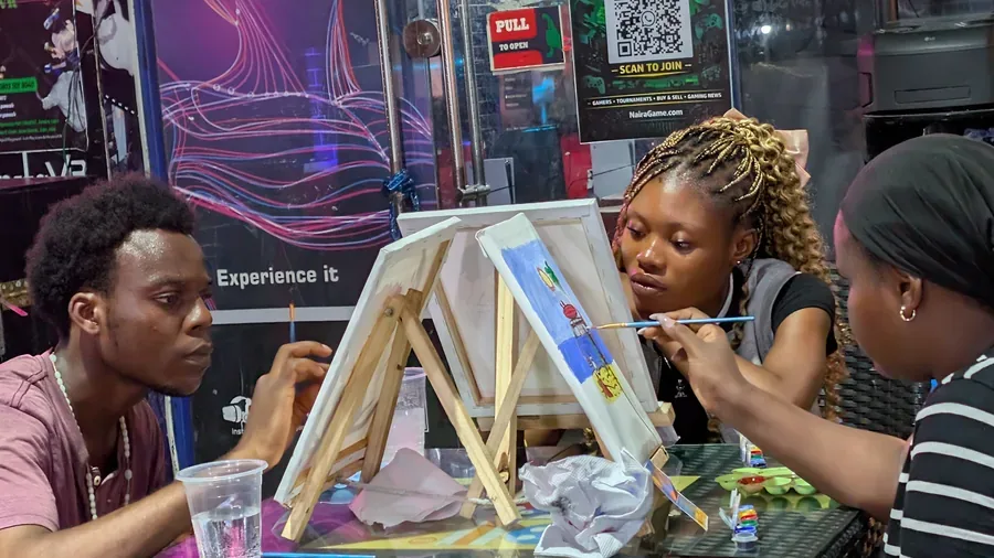Guests painting canvases during Paint Sip Play at Player One Game Cafe
