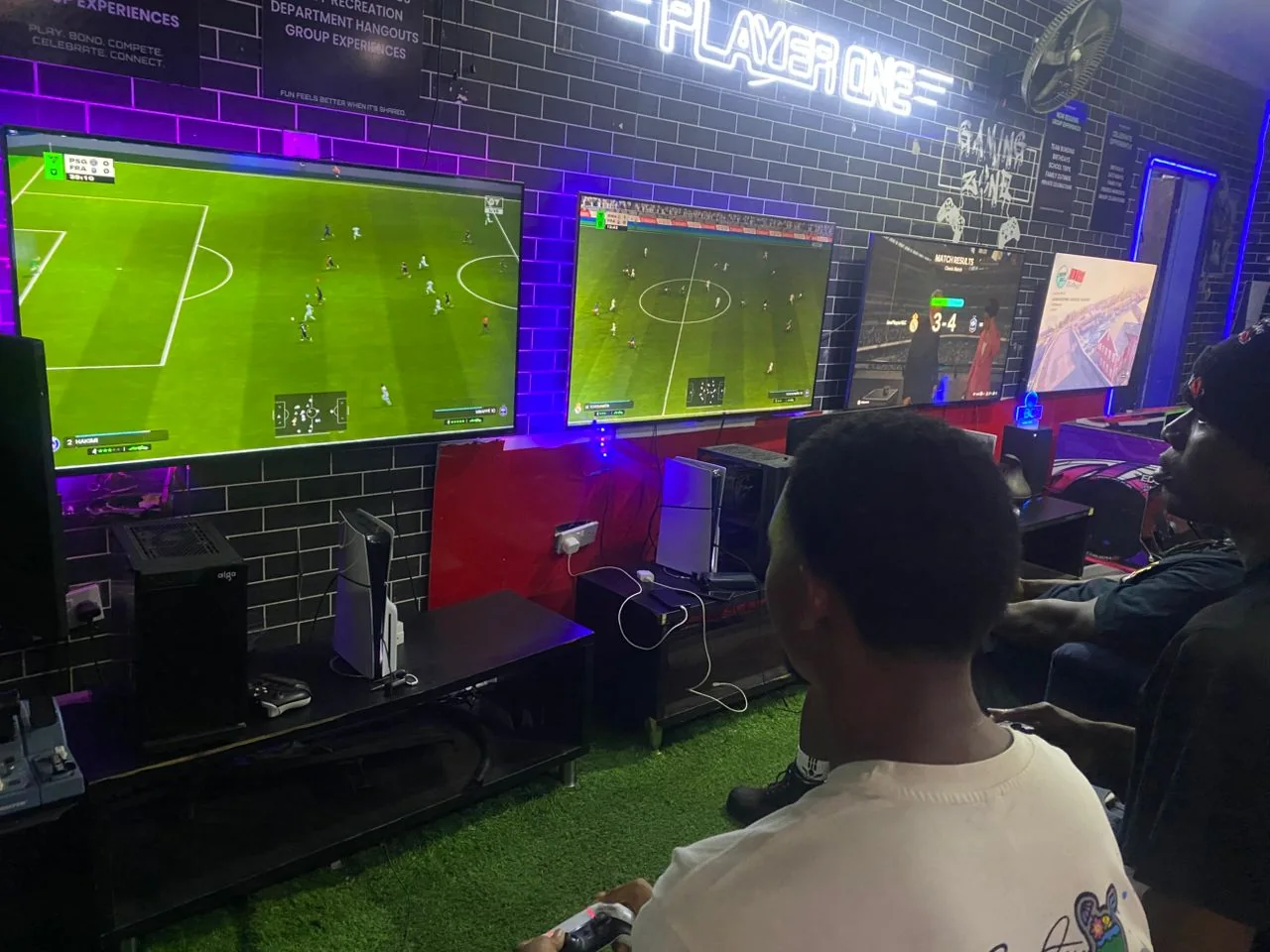 Guests playing FC football across multiple PS5 screens at Player One Game Cafe